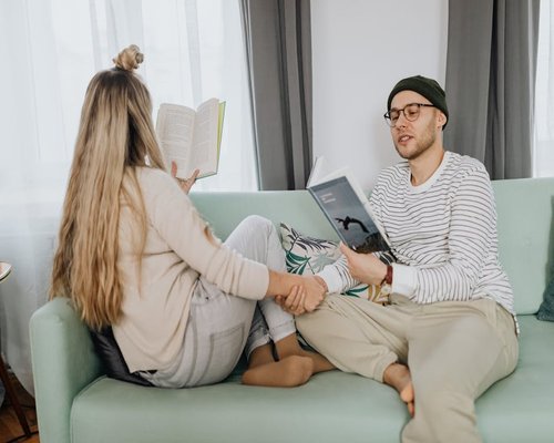 Man sitting peacefully on comfortable sofa reading a book