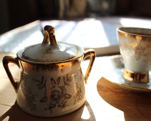 Cup of warm herbal tea on a wooden table with morning sunlight