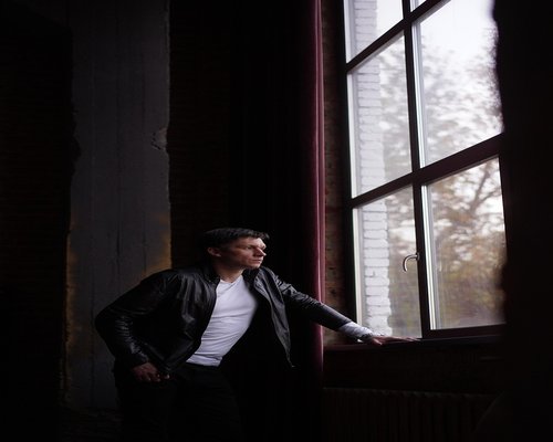 Man standing by the window practicing deep breathing and mindfulness